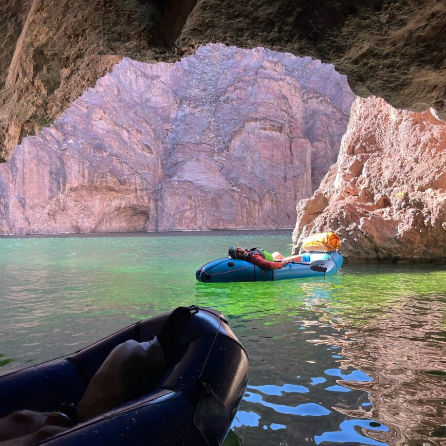 black canyon of the colorado river - a packrafter laying on the back of her alpacka raft resting in emerald cave