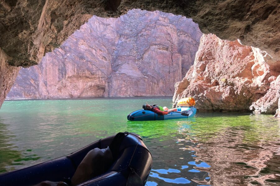 black canyon of the colorado river - a packrafter laying on the back of her alpacka raft resting in emerald cave