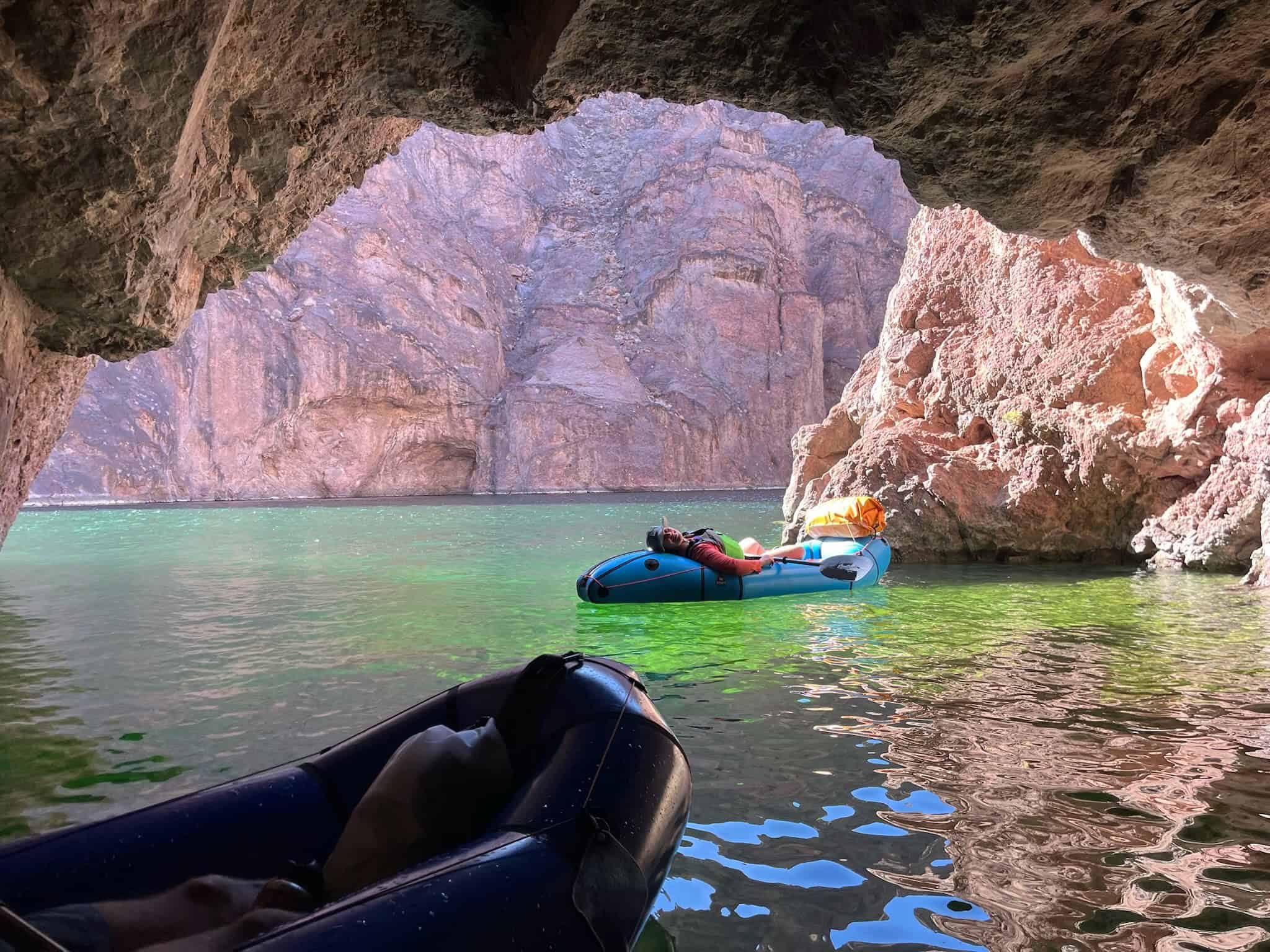 black canyon of the colorado river - a packrafter laying on the back of her alpacka raft resting in emerald cave